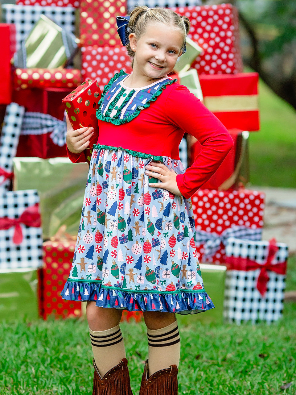 Candyland Christmas dress on a little girl holding a Christmas present.