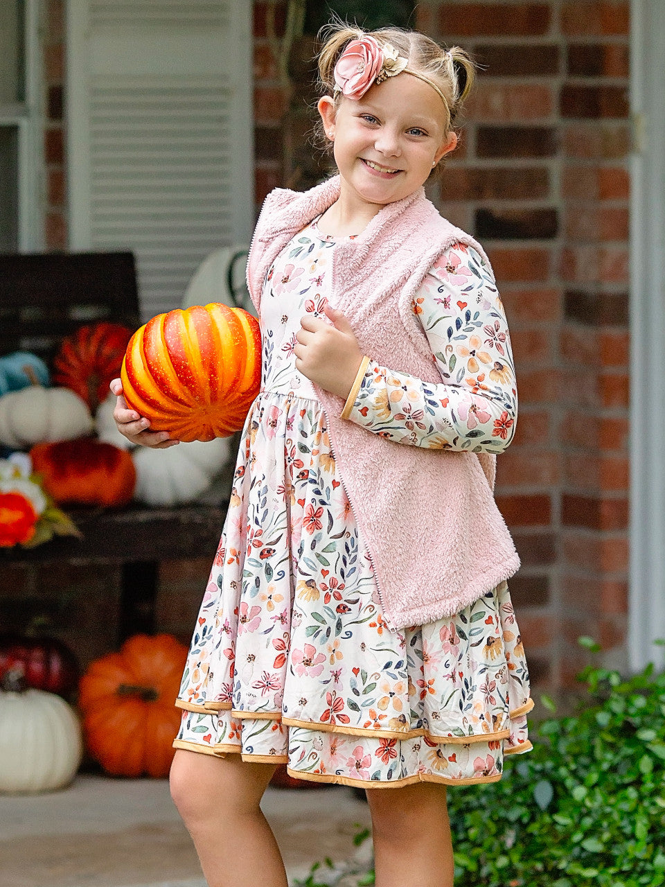 Floral double twirl dress for fall on a model holding a pumpkin.