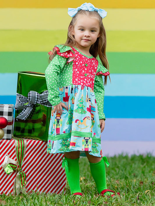 Nutcracker themed dress with ruffles on a posed little girl in front of a rainbow wall.