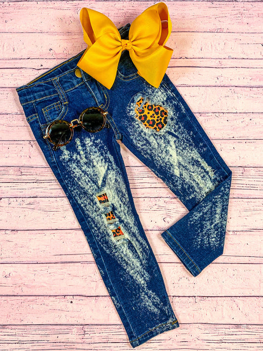 Distressed denim jeans with peek-a-boo animal print patchwork.