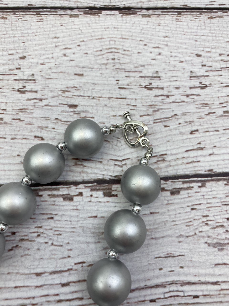 Silver chunky bead necklace has a toggle closure.