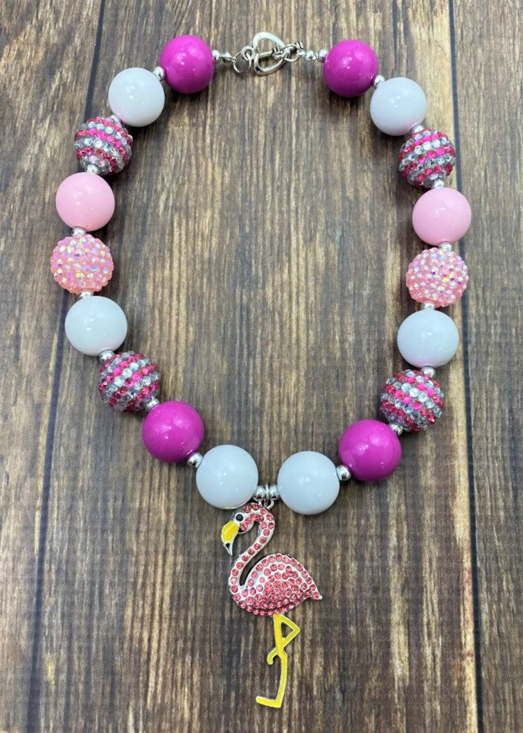 Pink rhinestone flamingo pendant chunky bead necklace with a mix of sparkly, striped, and polka dot beads and a heart toggle closure.