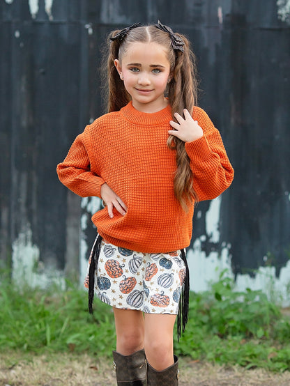 orange sweater with pumpkin fringe skirt outfit on a model