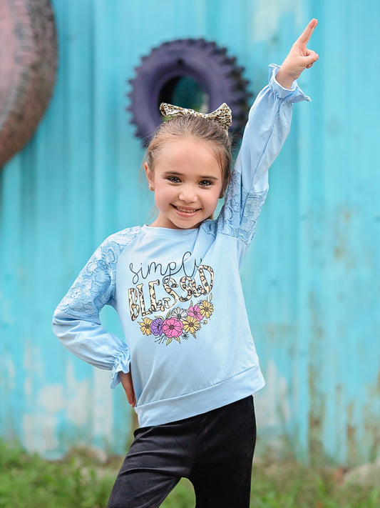 blue simply blessed top with flowers on a model