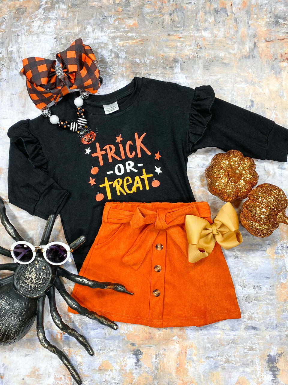 Trick or treat black top with orange skirt featuring button details and a tie belt.