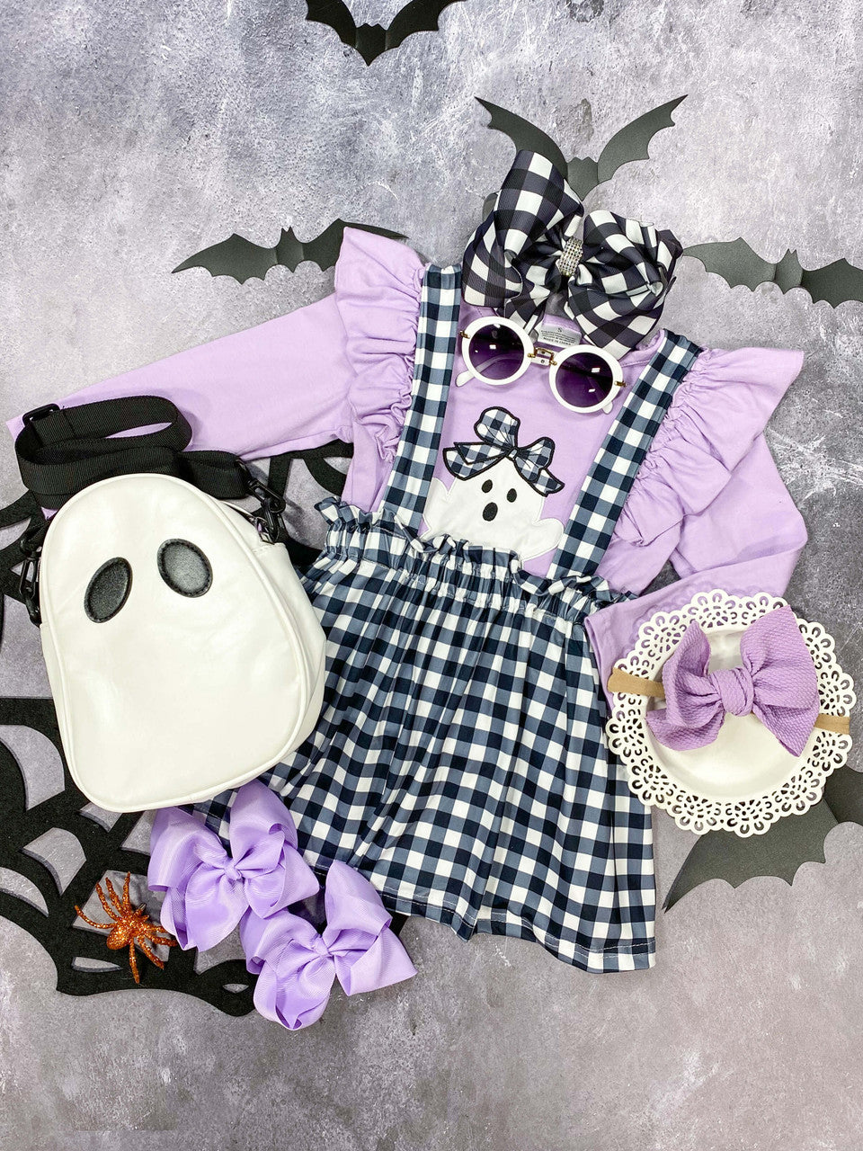 Black and white plaid suspender skirt with purple ghost appliquéd long sleeve top. 