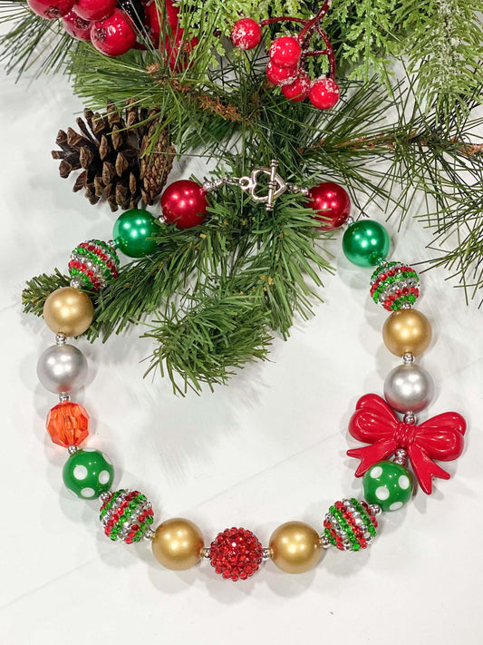 Festive red, green, and gold beads with a red bow-shaped accent bead and a heart toggle closure.