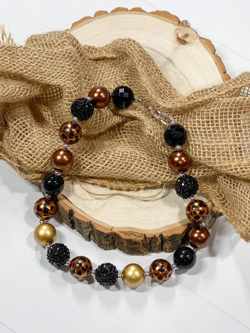 Girl's chunky bead necklace with black, gold, and leopard print beads.