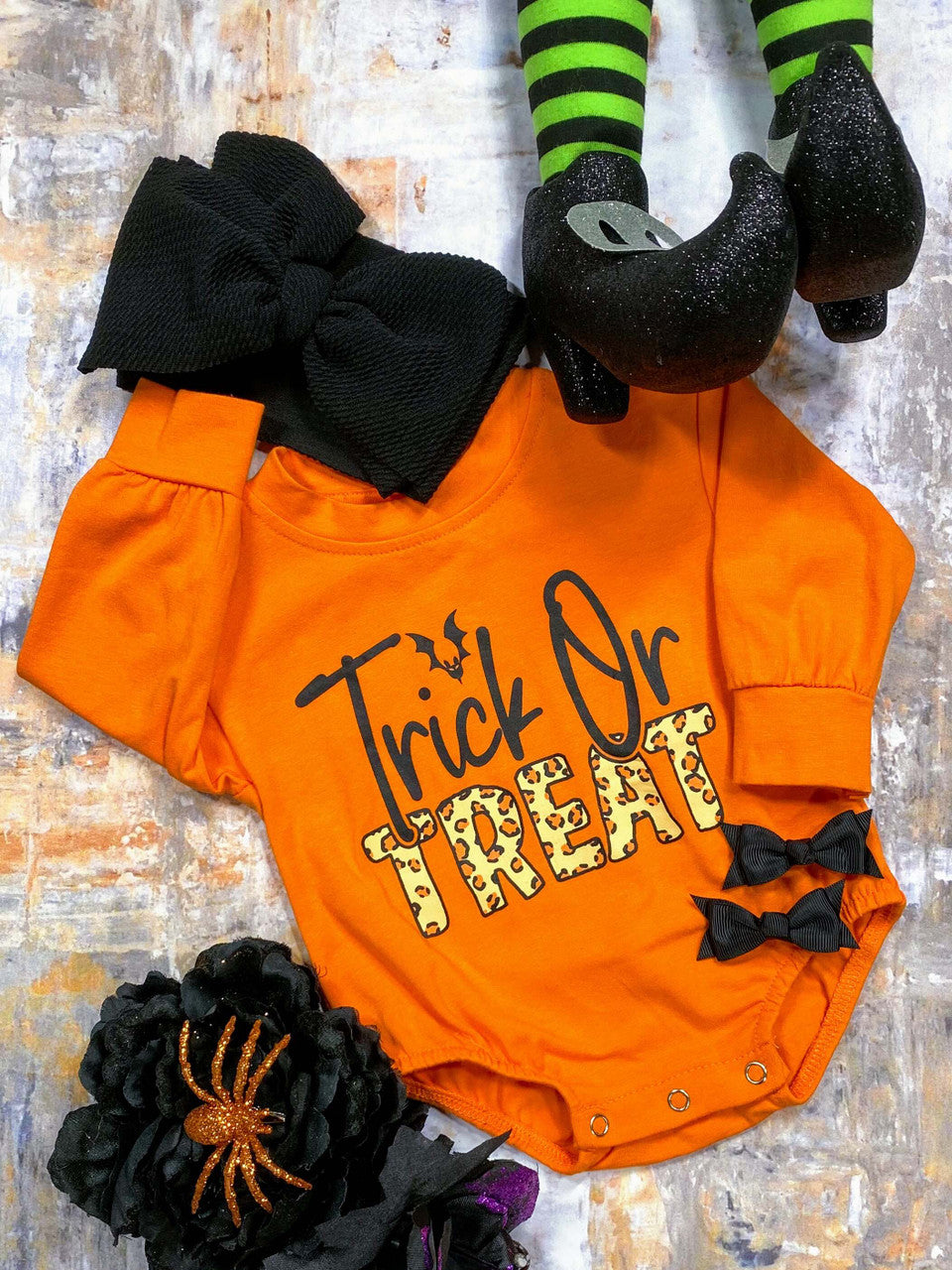 orange baby onesie with "trick or treat" screen print and animal print