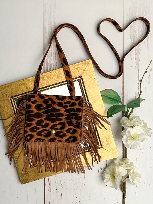 Caramel brown leopard print soft suede boho crossbody purse for girls with fringe-trimmed flap closure.