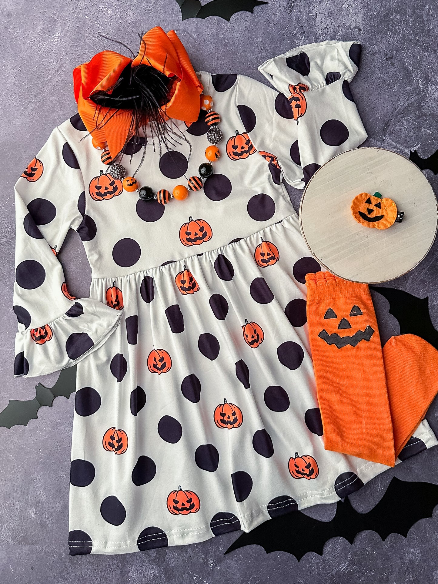 White long sleeve dress with black polka dots and orange jack-o-lanterns