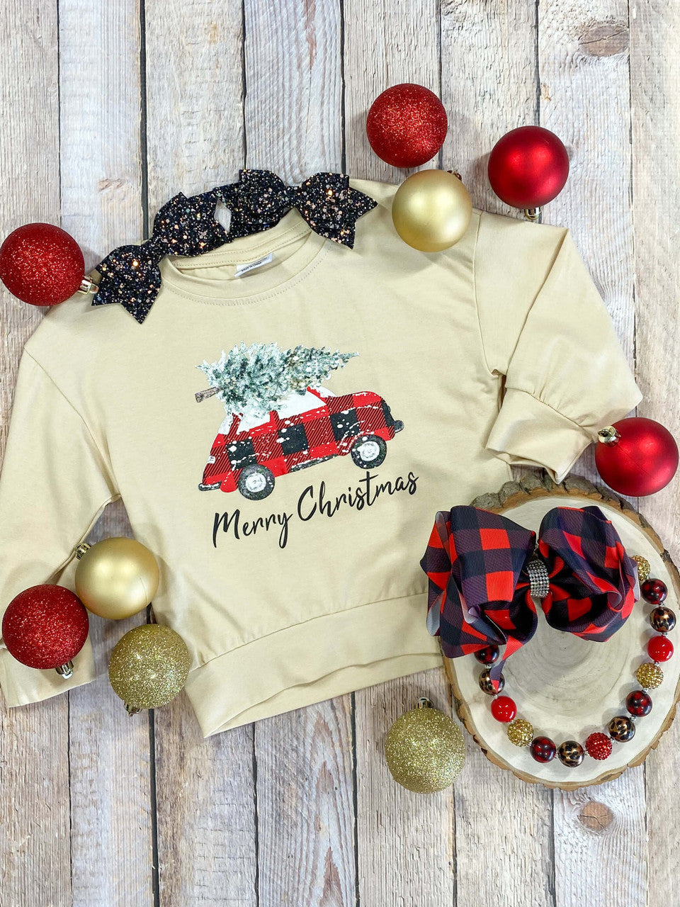 Cream long sleeve top with tree-hauling car design