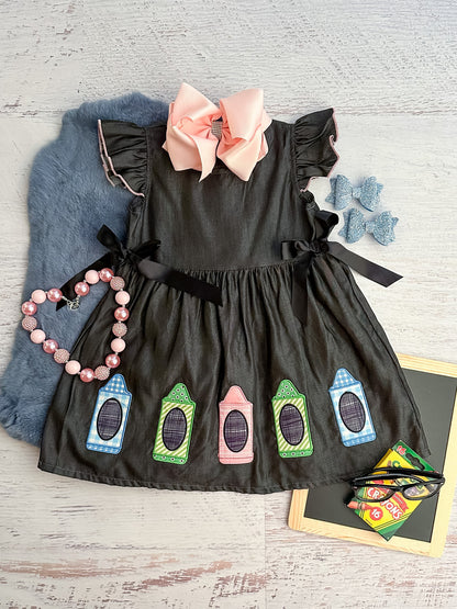 dark gray twirl dress featuring pastel-colored crayons and black ribbons