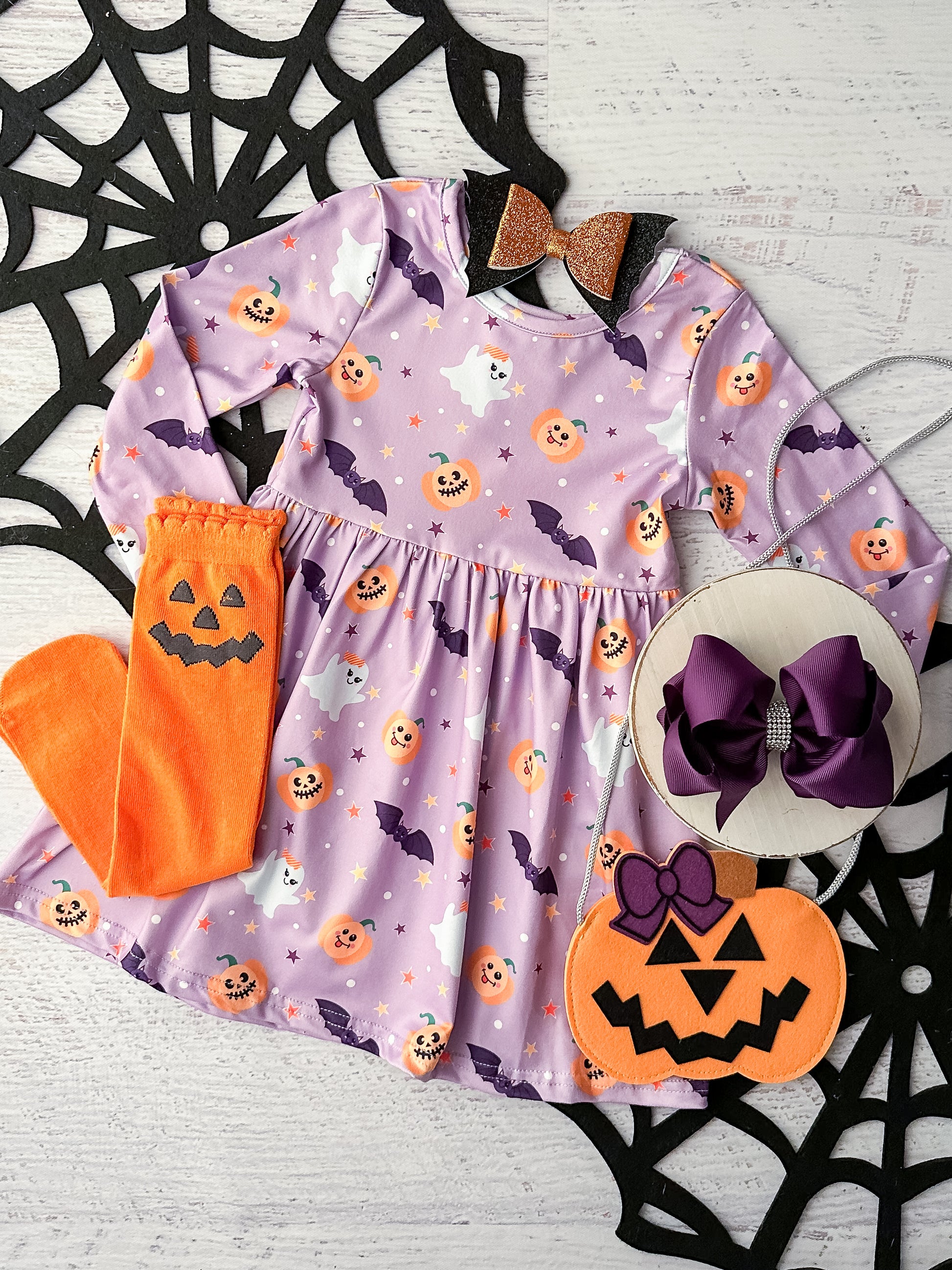 Light purple long sleeve dress in a cute spooky fabric of pumpkins, bats and ghosts.