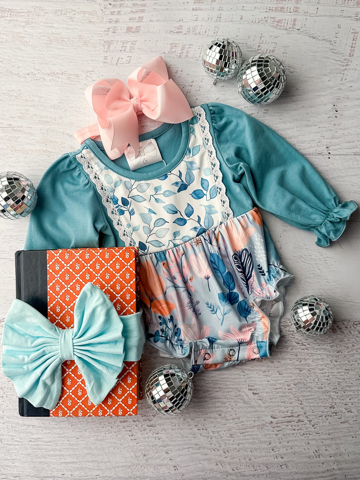 Long sleeve infant romper in a teal color & floral watercolor print.