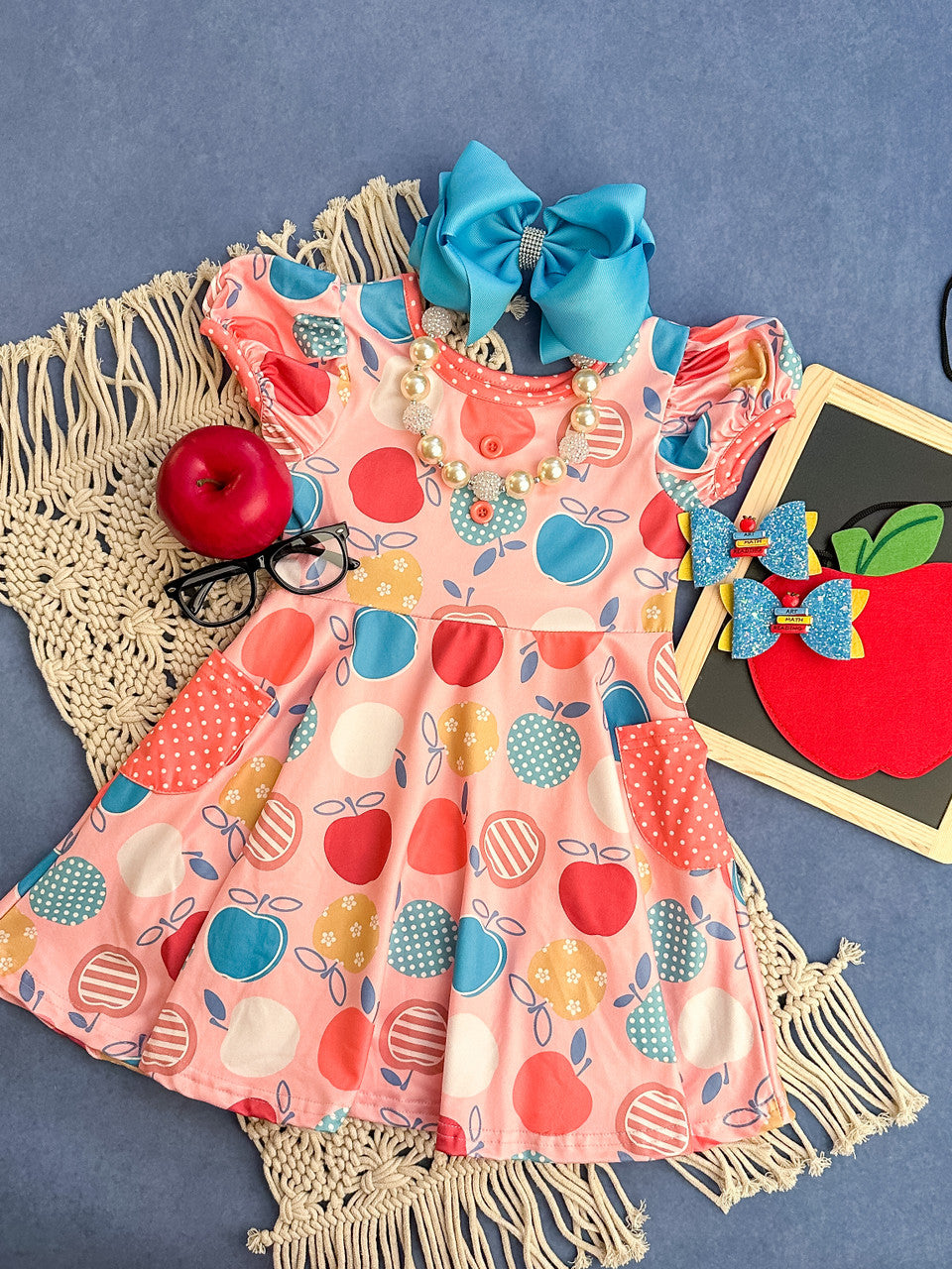 pink twirl dress with multiple print apples and polka dot pockets