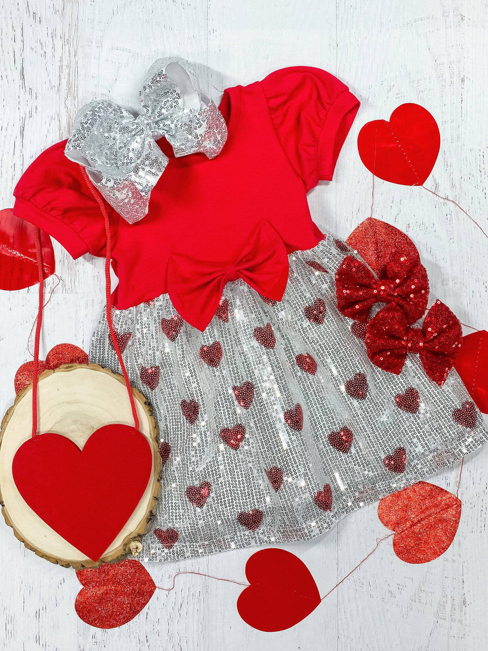 Red top with silver sequin bottom dress with red sequin hearts and a bow at the waistline.