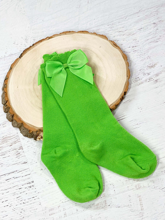 Over the calf red socks with lime green satin bow. 