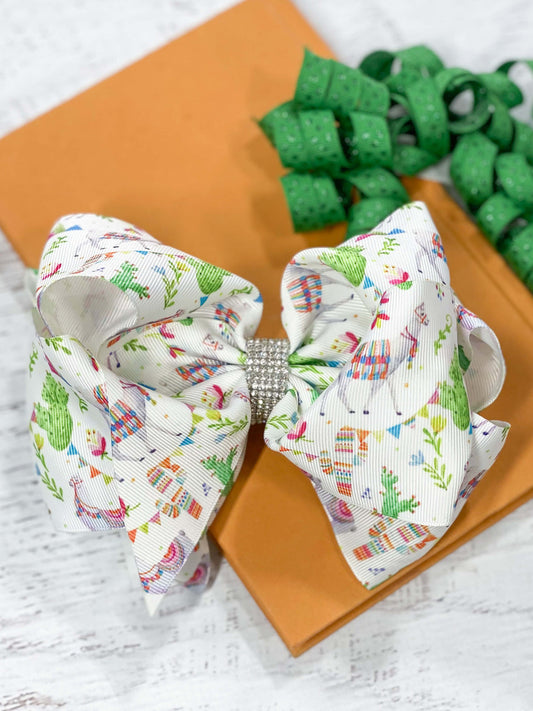A large double looped llama, cactus, and succulents print grosgrain ribbon hair bow with an elegant 1/2" strip of six rows of tiny rhinestones around the center.