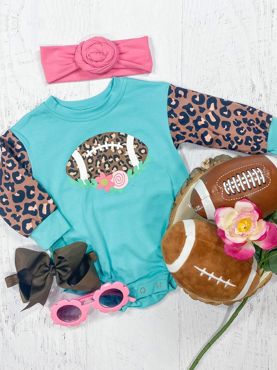 Turquoise and leopard onesie with a floral football design and snap closure.