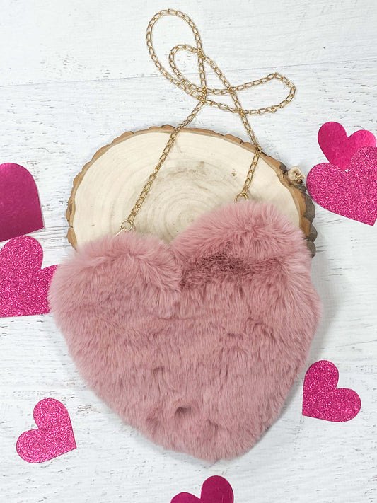 Pink fuzzy heart purse with gold chain for shoulder carrying and a gold zipper opening