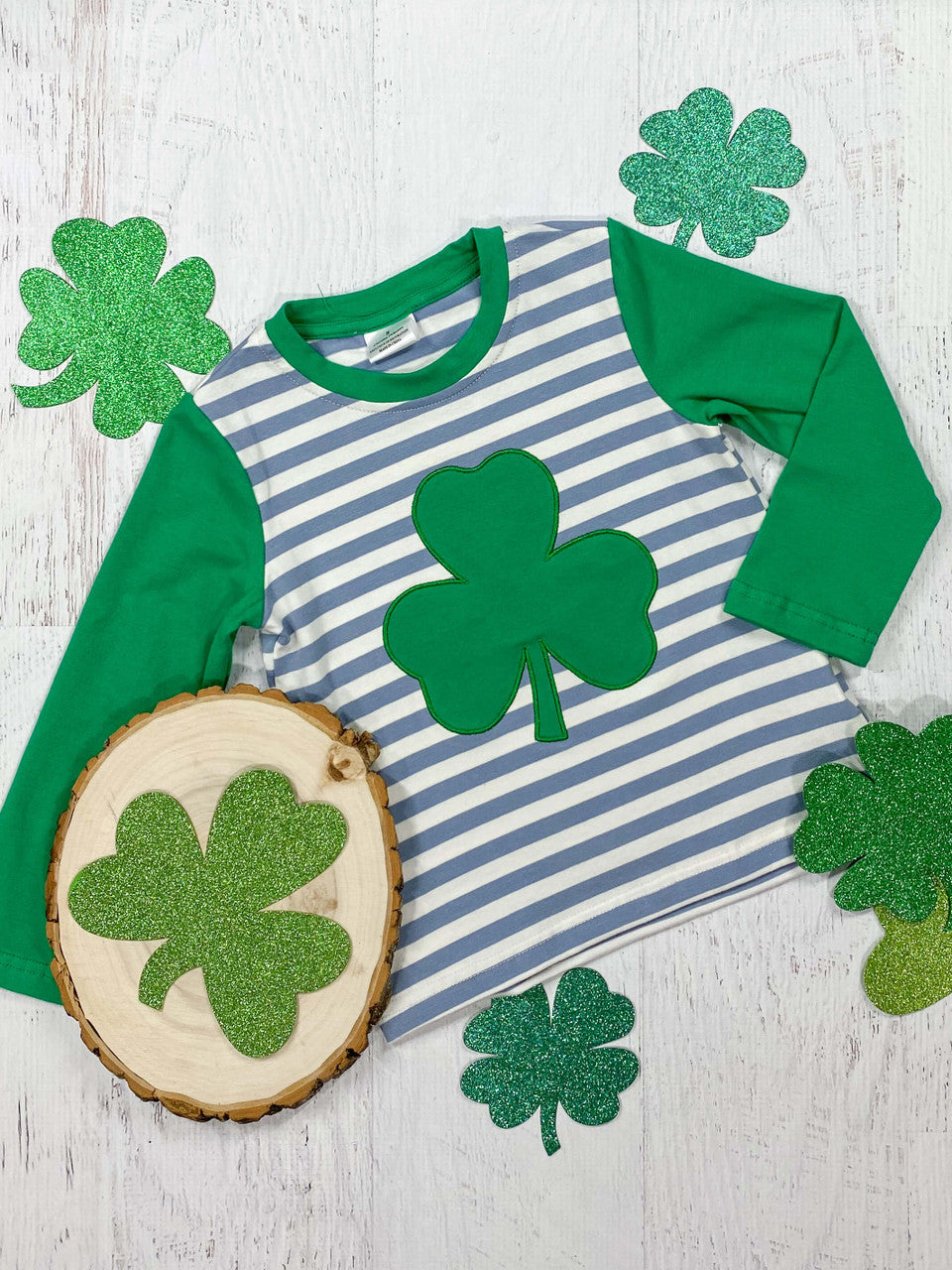 White & Blue Striped Shirt With Green Long Sleeve's & A Shamrock Print.