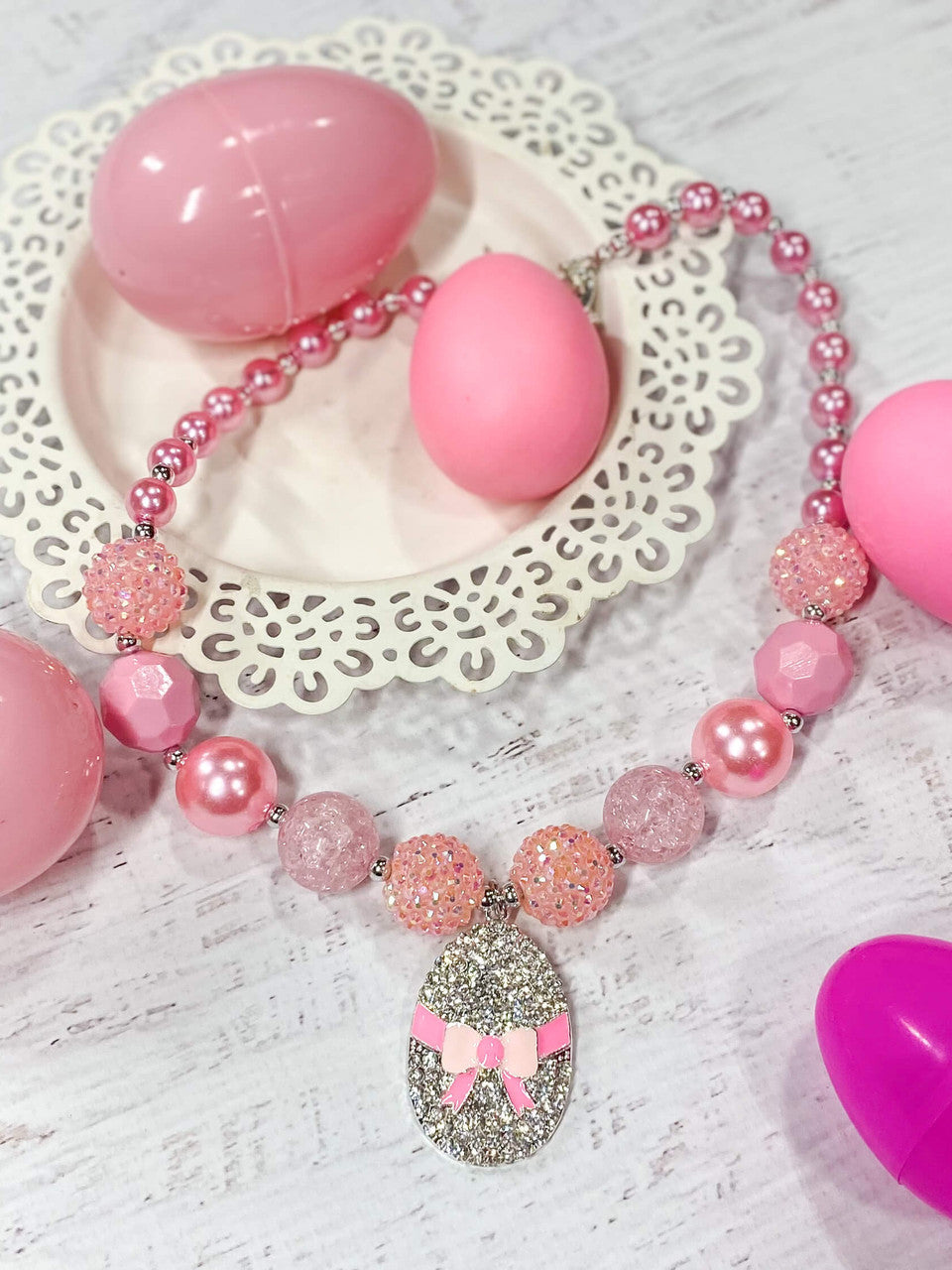 Silver rhinestone Easter egg with pink bow pendant chunky bead necklace with a mix of sparkly, pink pearl, and solid pink beads and a heart toggle closure.