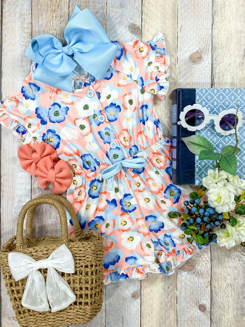 Coral and blue floral print romper with a cinched waist and buttons on the top half