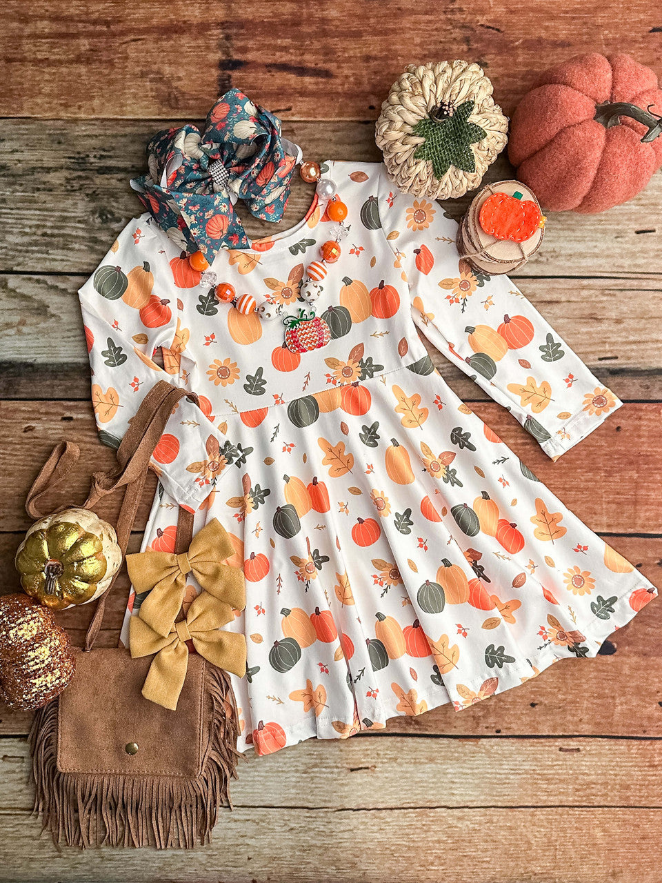 white long sleeved dress with an abundance of cut pumpkins