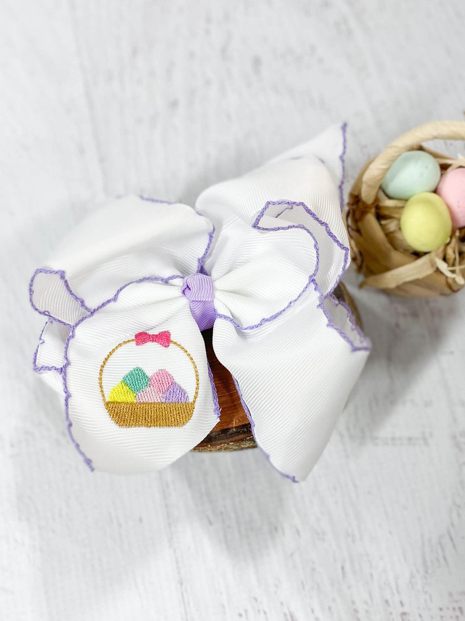 White with purple moonstitch hair bow with embroidered egg basket design on left tail