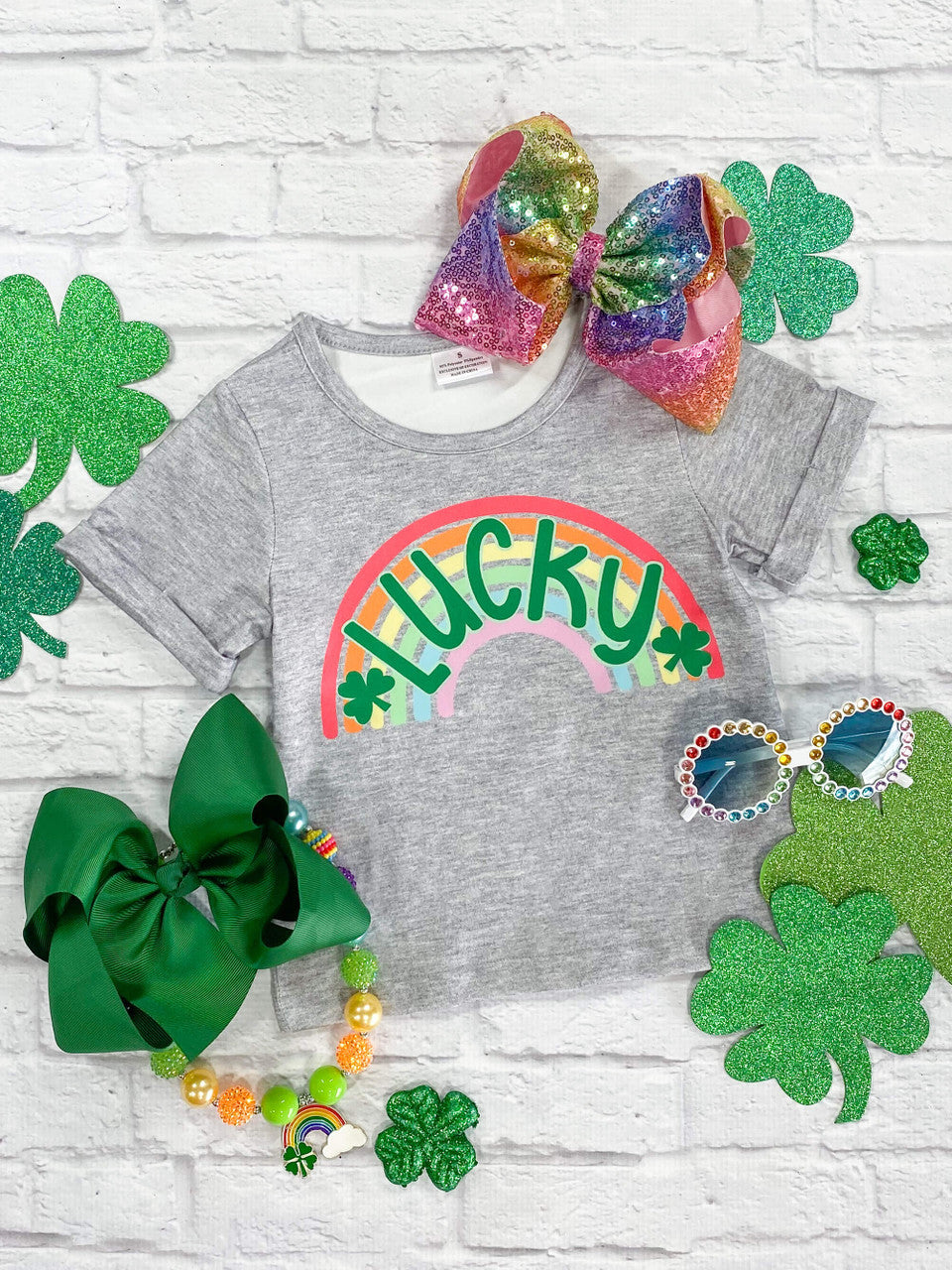 Green lettering "Lucky" with two shamrocks on top of a rainbow, cuffed sleeve top.