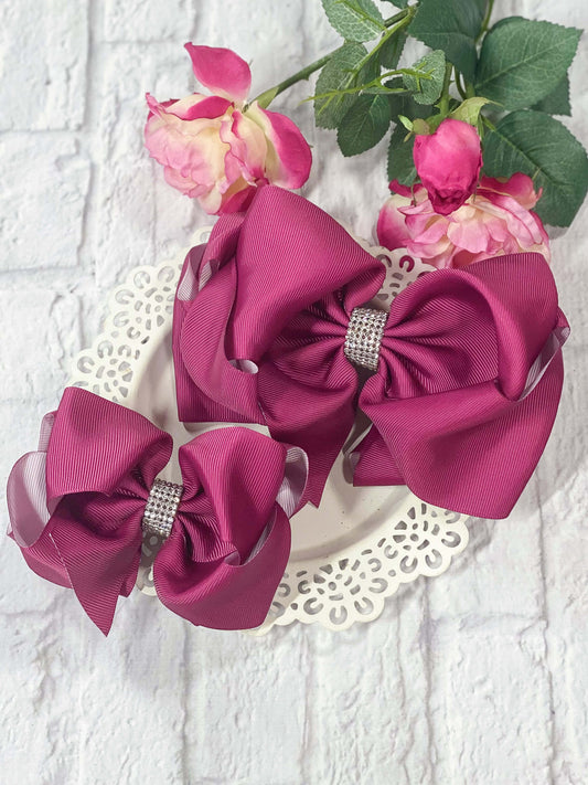Plum rhinestone center hair bows with white on the underside of the grosgrain ribbon.
