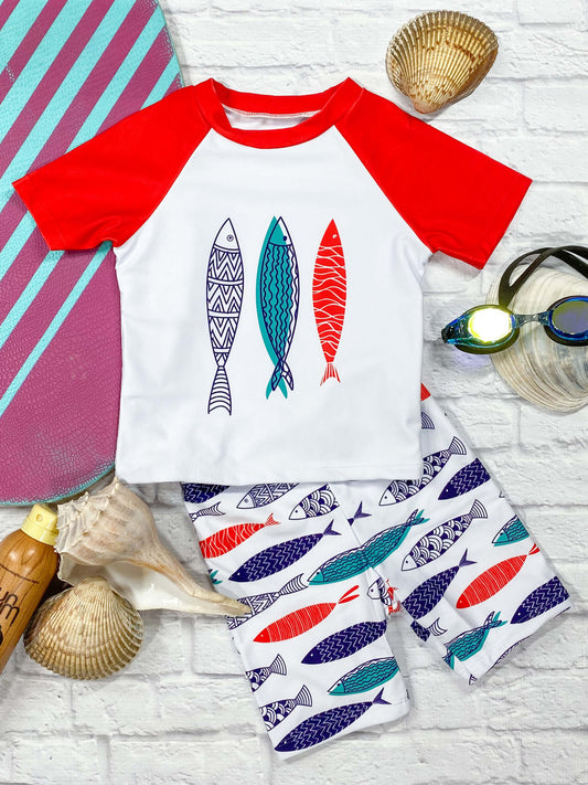 Red raglan short sleeve, blue, white, and red fish pattern swim shirt paired with blue, red, and white fish pattern trunks.