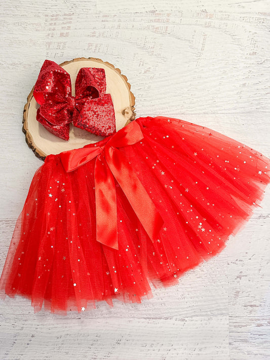 Red tulle tied tutu (tulle is looped around the elastic waist) with sparkle stars and red bow accent.