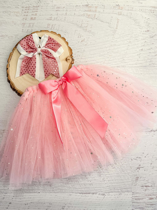 Pink tulle tied tutu (tulle is looped around the elastic waist) with sparkle stars and pink bow accent.