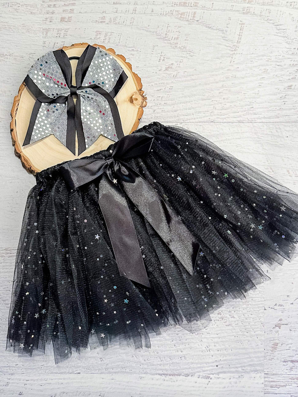 Black tulle tied tutu (tulle is looped around the elastic waist) with sparkle stars and black bow accent.