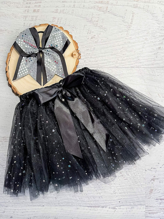 Black tulle tied tutu (tulle is looped around the elastic waist) with sparkle stars and black bow accent.