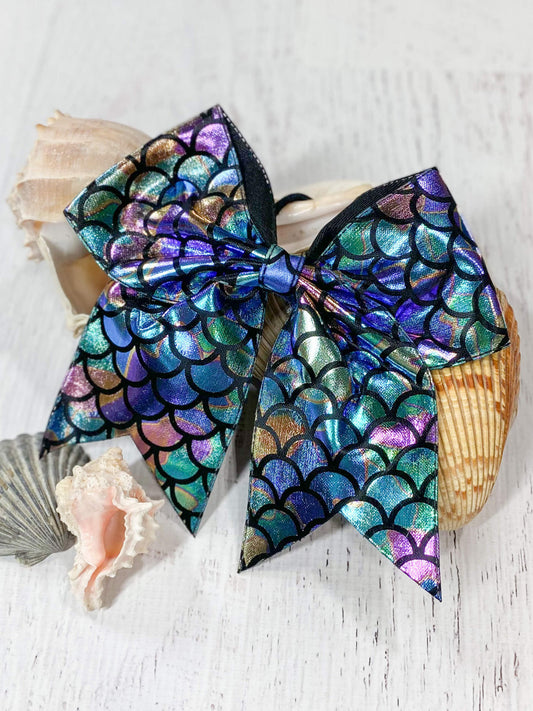Mermaid cheer bow in metallic rainbow fish scale pattern. Approximately 6" across with 6" tails.