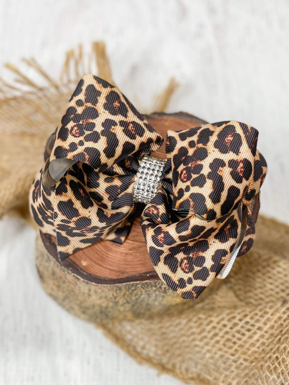 Our oversized double looped leopard print grosgrain ribbon hair bow with an elegant 1/2" strip of six rows of tiny rhinestones around the center