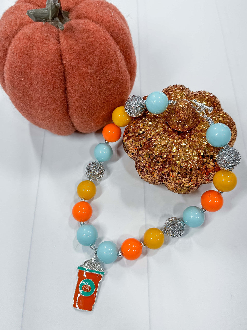 Orange, blue and yellow rhinestone chunky bead necklace with pumpkin spiced latte pendant; measures approx. 17" with toggle closure.