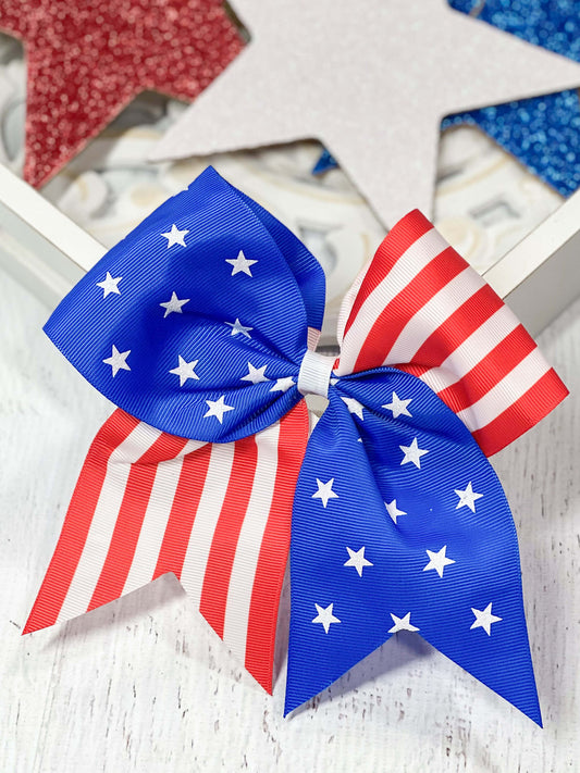 Flag print cheer style bow with tails with alligator clip backing.