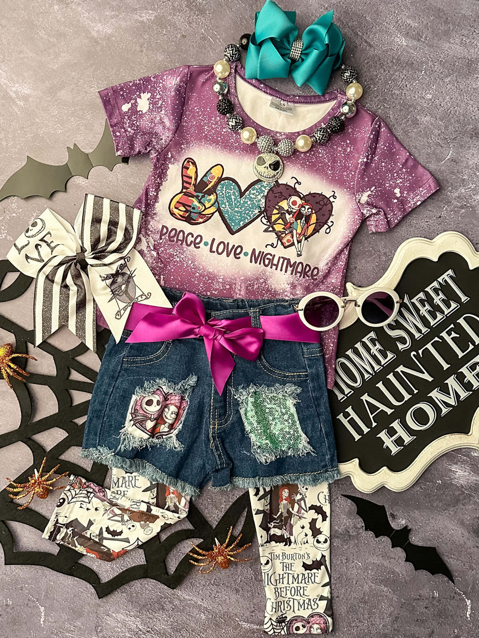 3-Piece outfit including a cuffed purple bleach speckled t-shirt for girls with "Peace Love Nightmare" printed below The Nightmare Before Christmas related image depictions of each word, denim shorts, and coordinating leggings. 