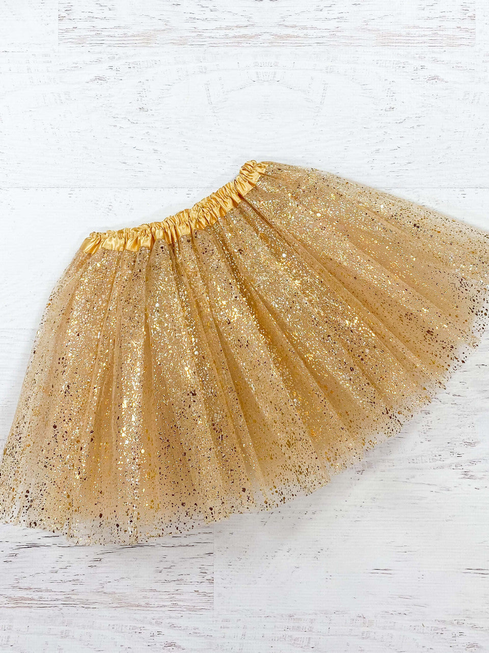 Gold tulle tutu with a metallic gold "splatter." The waist is a stretchy satin lined material to fit a wide age range and the tulle skirt is about 11."  Available in one size only, this tutu fits most kids between 2-8 years.