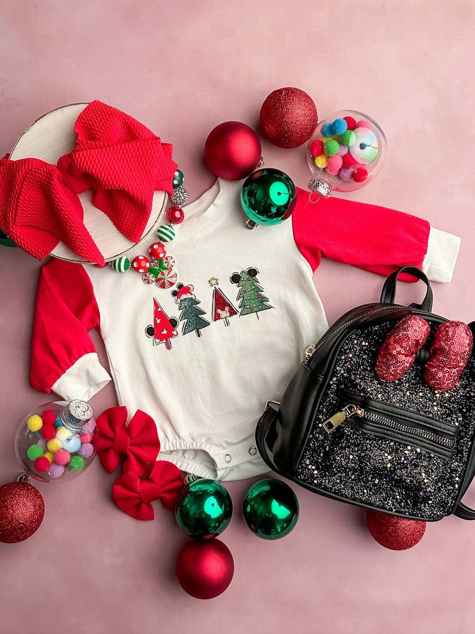 Long sleeve onesie with a white bodice and red sleeves with a Christmas tree design 