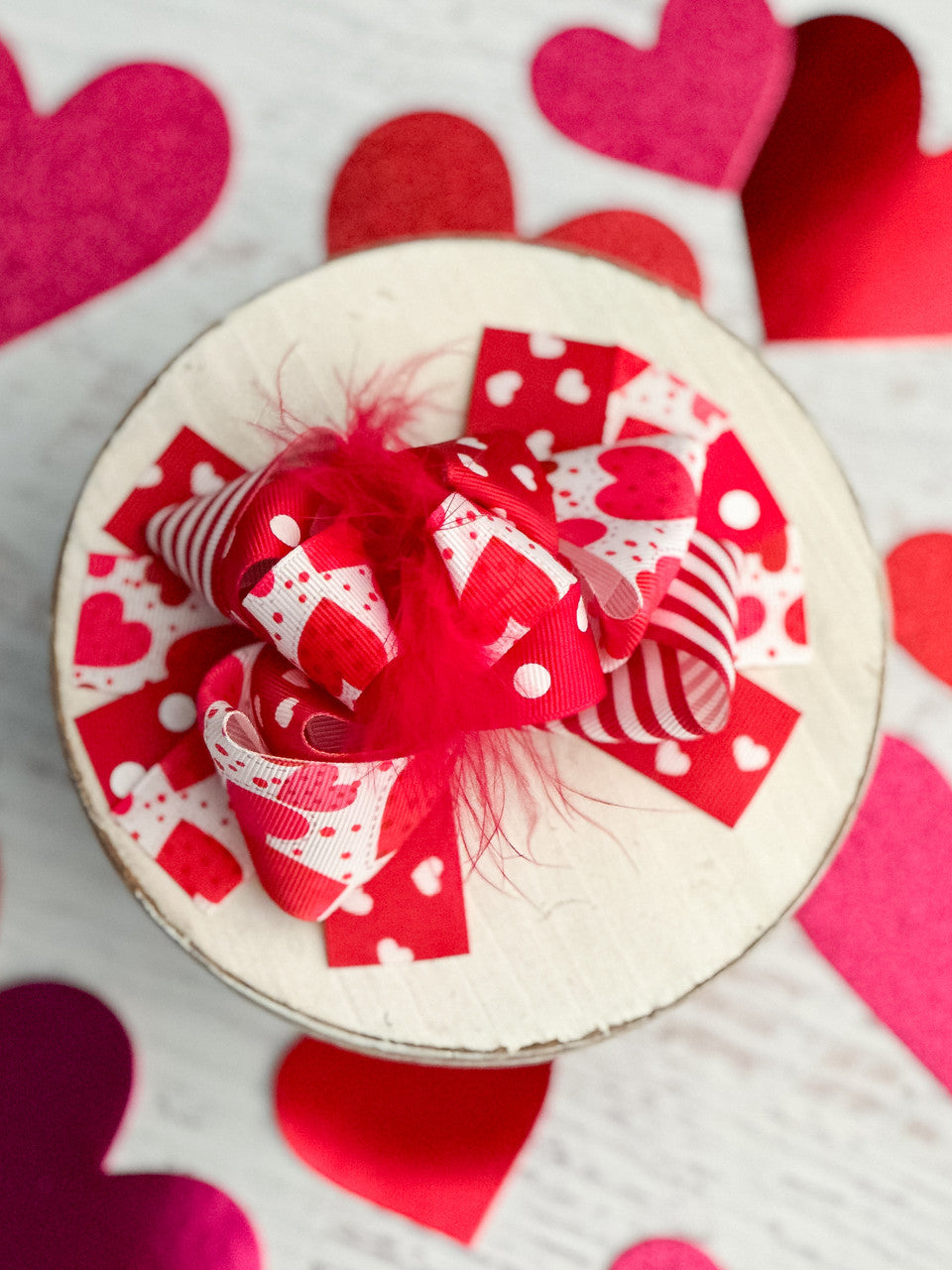 Hearts, stripes, and polka dots on 1-1.5" grosgrain ribbon loop around a fluffy red marabou puff to create this fun Valentine's Day hair bow.