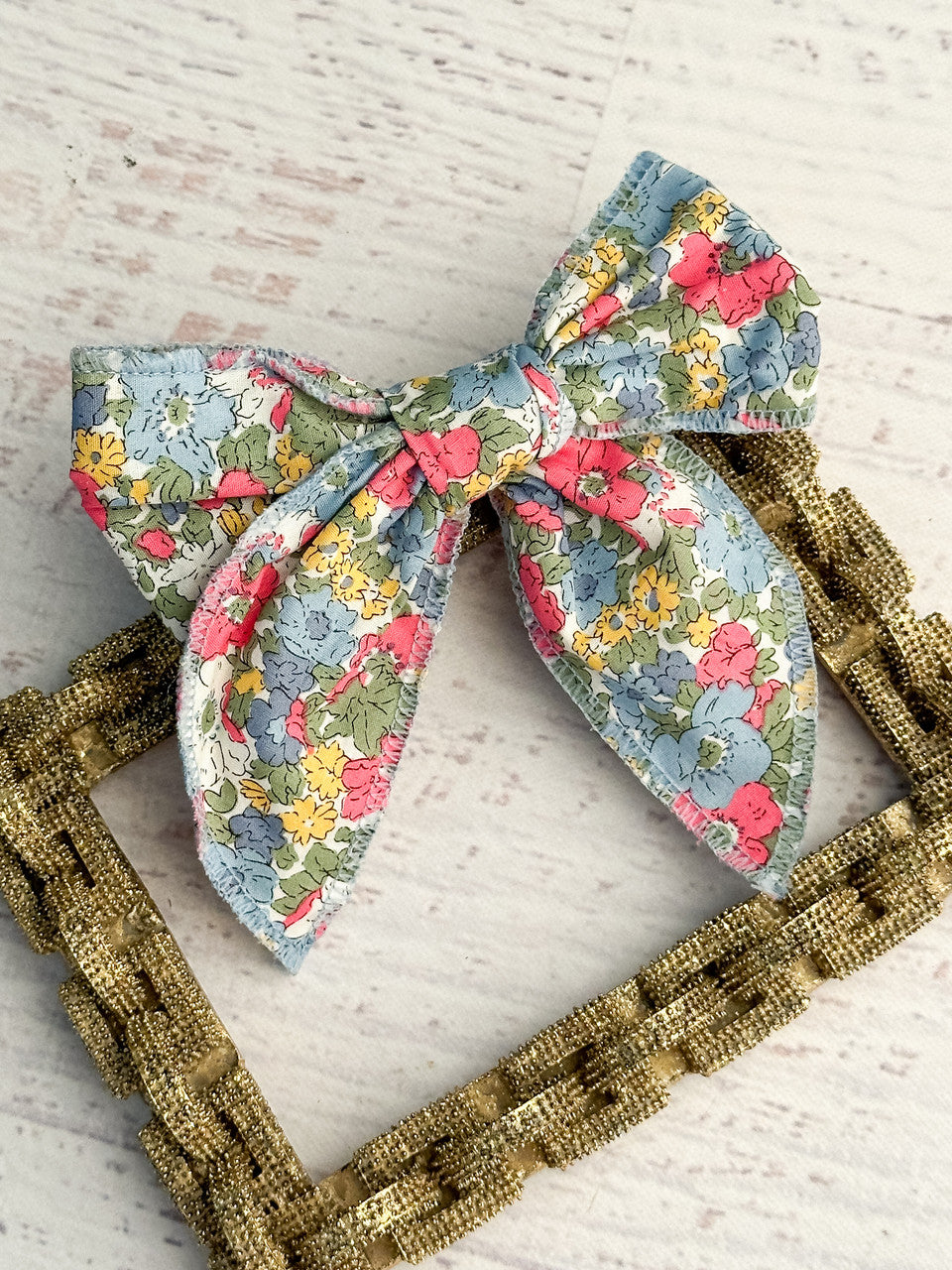 Pink & Blue floral print bow with removable single alligator clip. Measures approximately 5x5 inches.