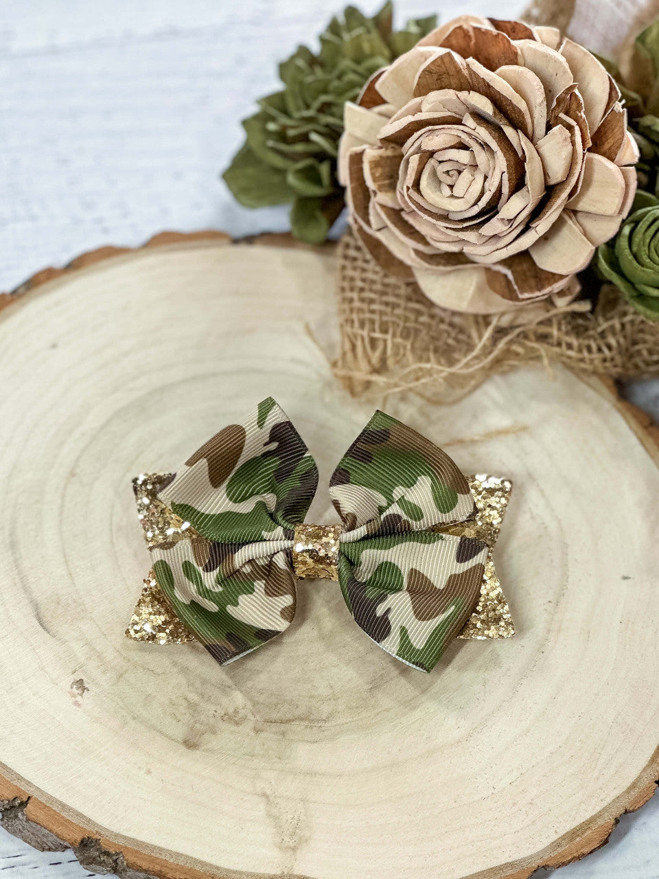 Camo print and gold glitter bow on a single alligator clip- approximately 4 inches across.