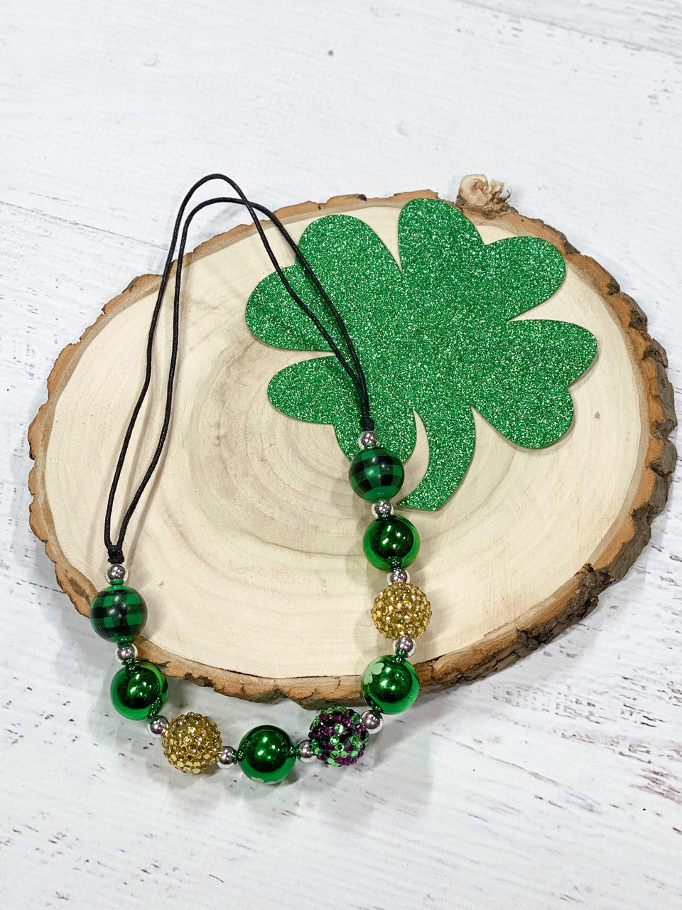 Adjustable wax-coated rope chunky bead necklace with green plaid, gold rhinestone, solid green, and white four-leaf clover beads.