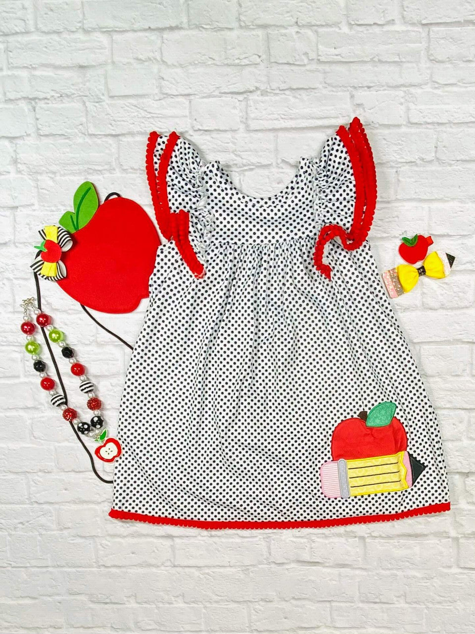 navy and white polka-dot dress with an apple and pencil