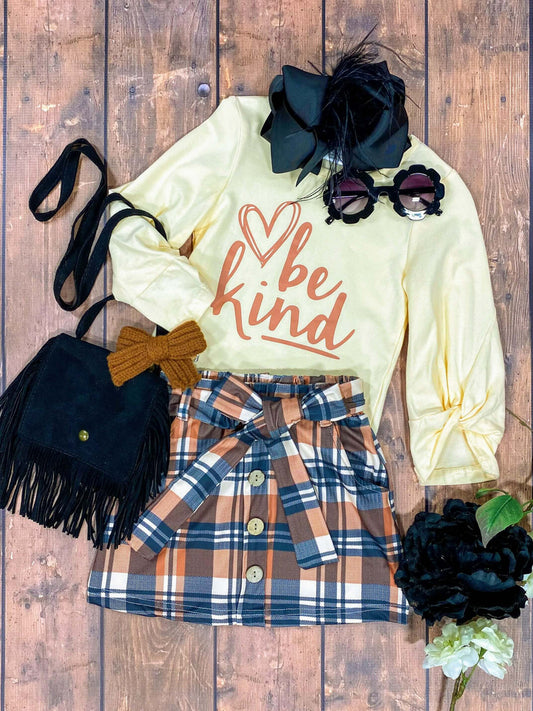 cream shirt with "be kind" cursive screen print with a plaid tie skirt set